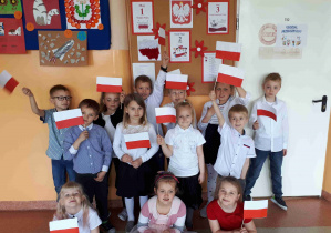 Dzieci trzymają wykonane przez siebie flagi Polski